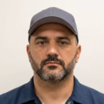 Agente de servicio al cliente de TruckerTrend con gorra y camisa azul, listo para asistir a conductores y empresas de transporte.